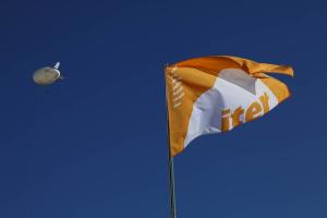 English: Photo of the yellow and white ITER Organization flag on the background of a perfectly blue sky. Français: Photo du drapeau jaune et blanc de l' Organisation ITER sur fond de ciel parfaitement bleu.